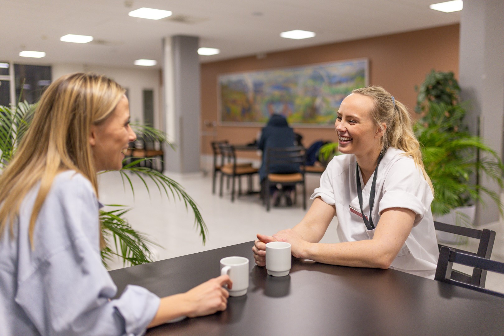 Sykepleierne Tuva og Elisabeth koser seg over en god kopp kaffe. 